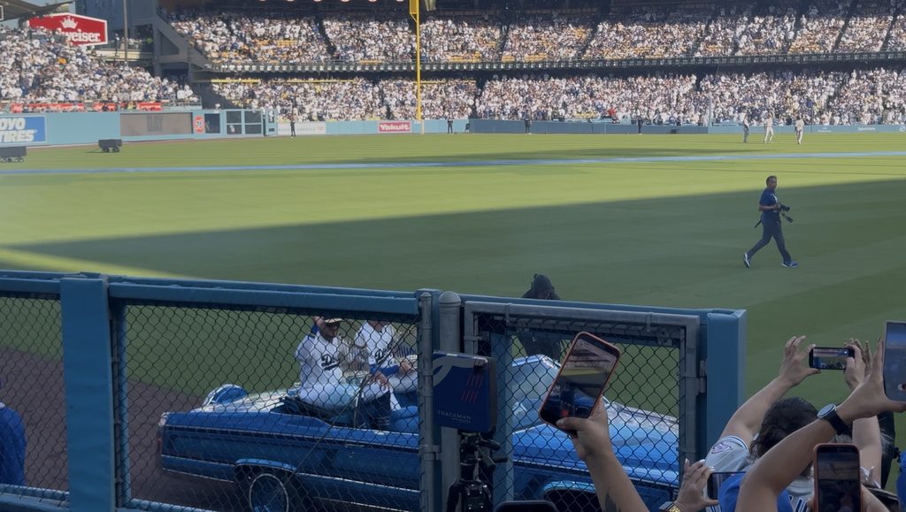 優勝トロフィーを持って車で凱旋するフリーマン選手とロハス選手
