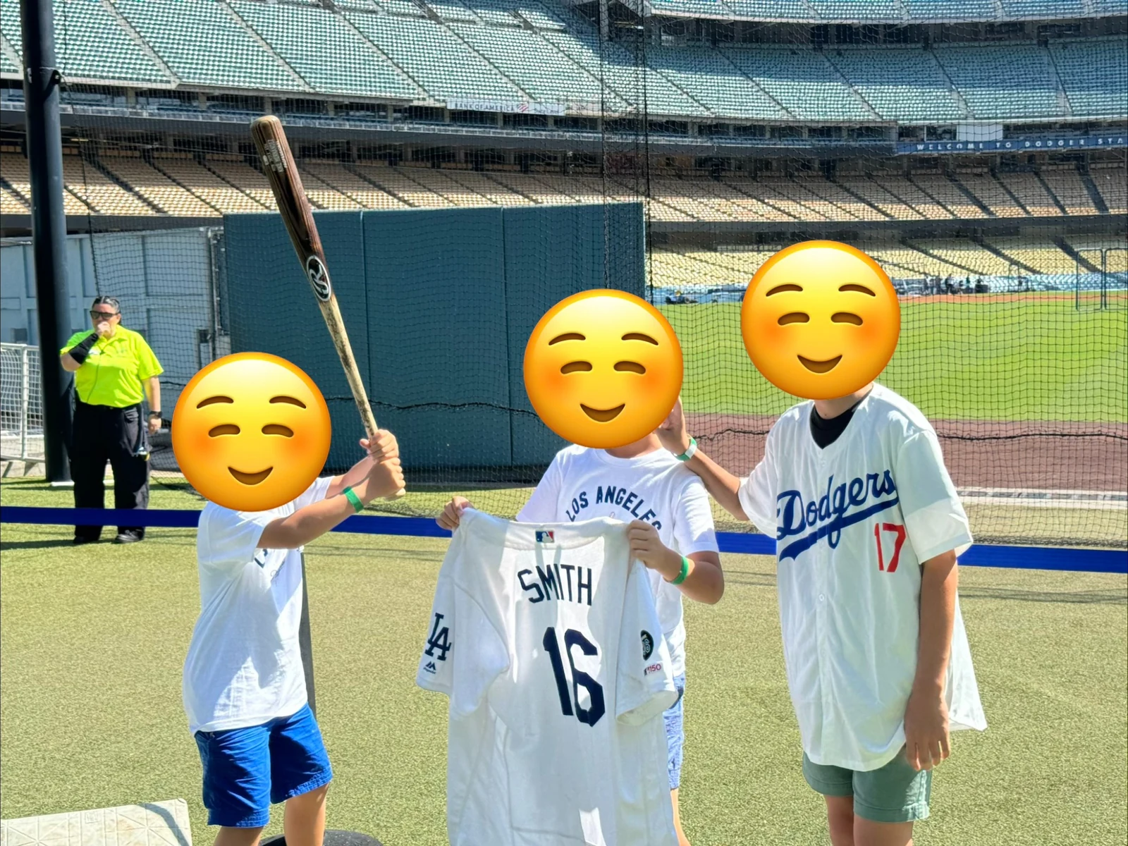 ドジャースタジアムのフィールド近くで記念撮影する3人の子ども