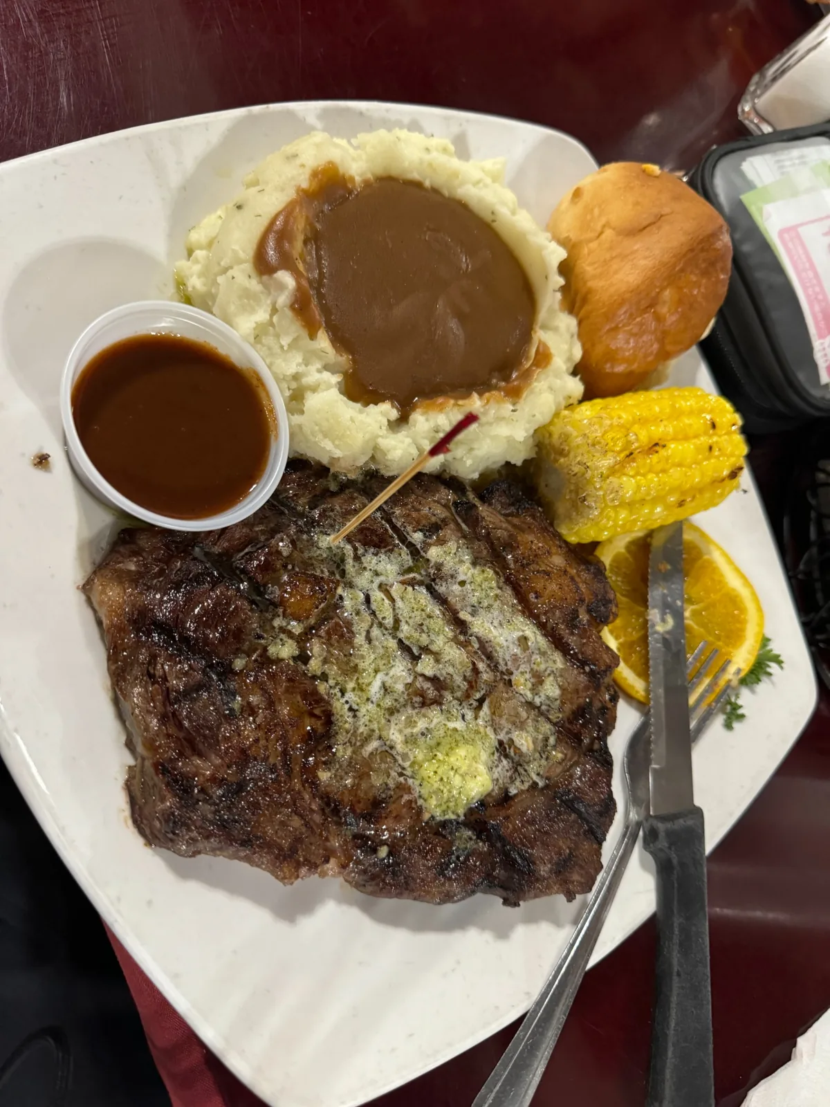 ステーキとマッシュポテト、コーン、パンの夕食